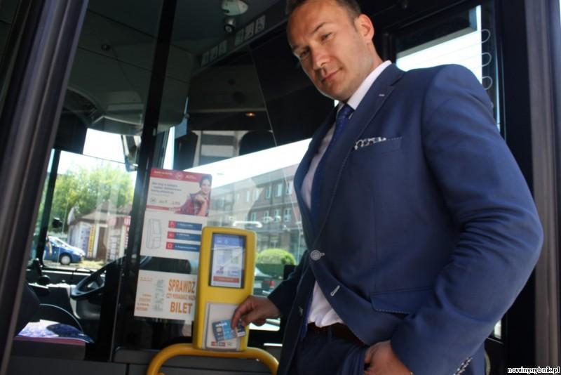 Grzegorz Wojtenko pokazuje, jak łatwo płaci się kartą zbliżeniową również w autobusie / Adrian Karpeta